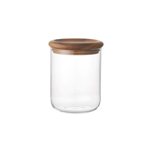 Clear glass jar with a wooden lid on a white background.