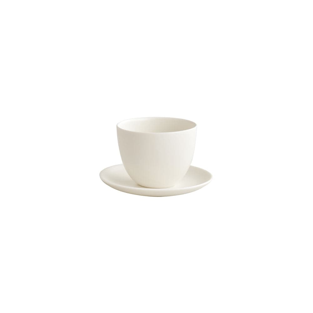 White ceramic cup on a matching saucer, viewed from the side.