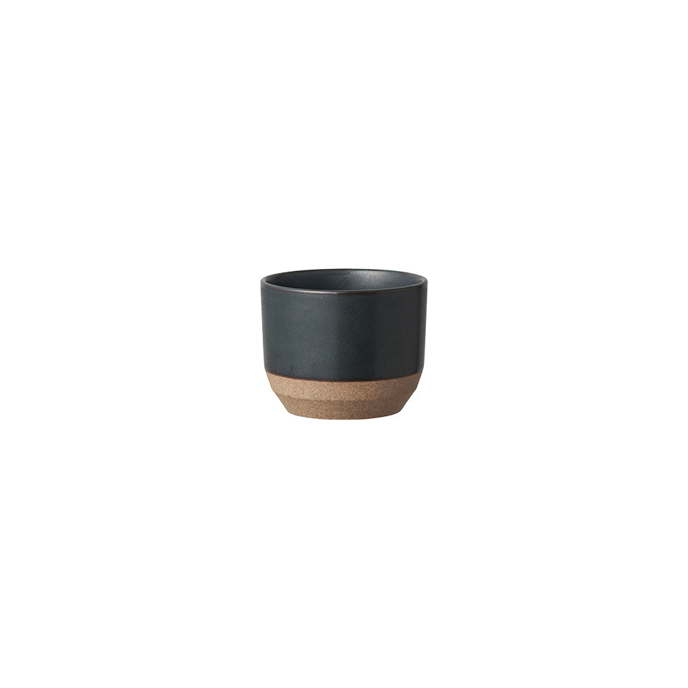 Small black ceramic cup with a natural brown base.