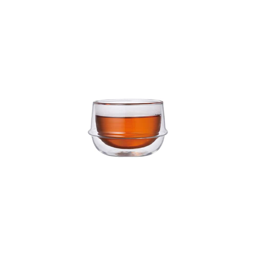 Short glass cup with amber liquid inside, on a white background.