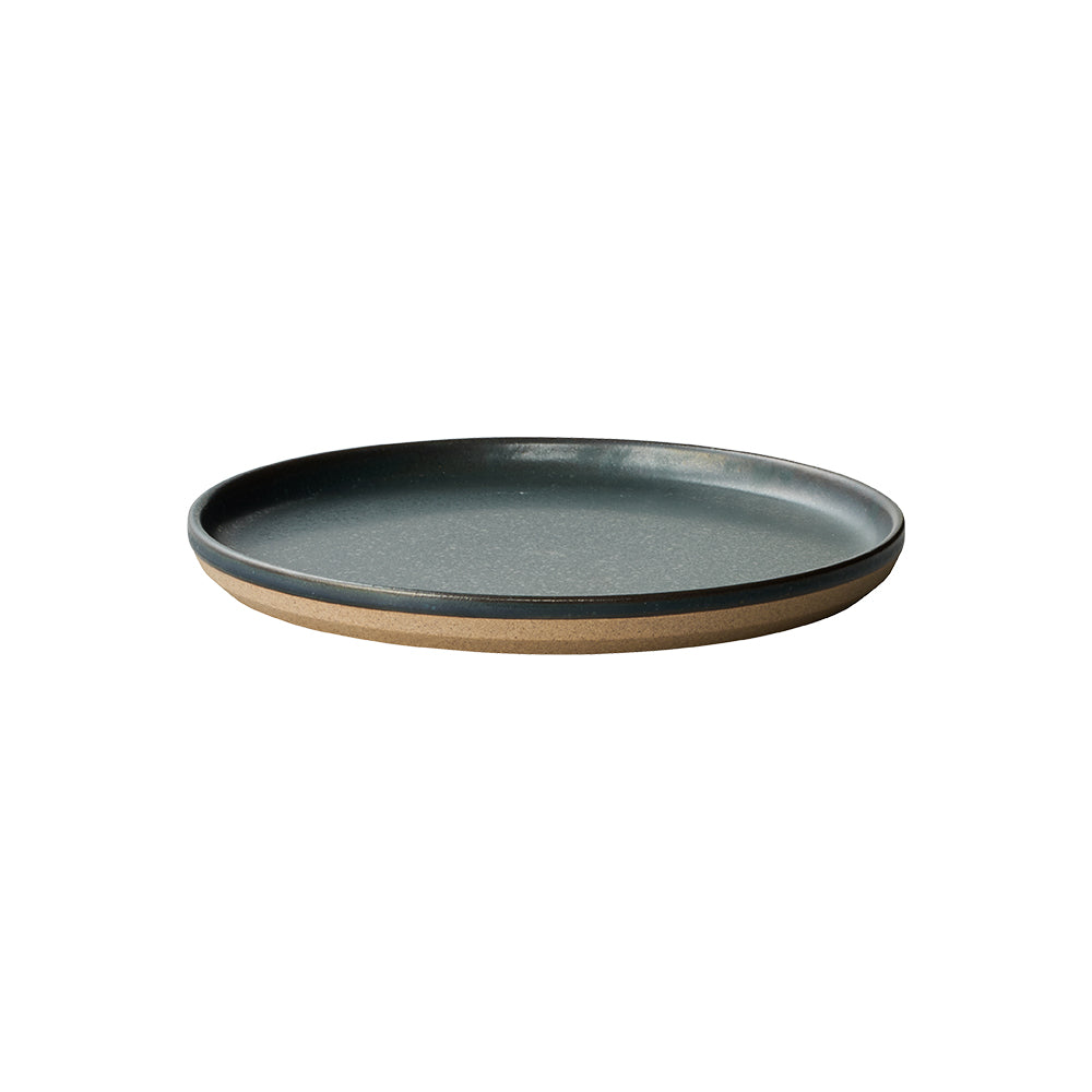 Round black ceramic plate with a natural brown bottom.