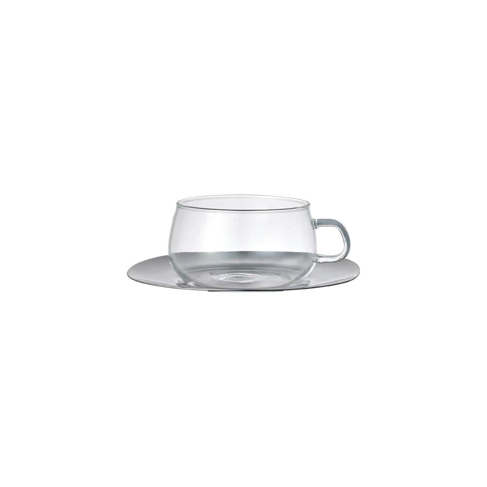 A clear glass cup with a handle on a matching saucer against a white background.
