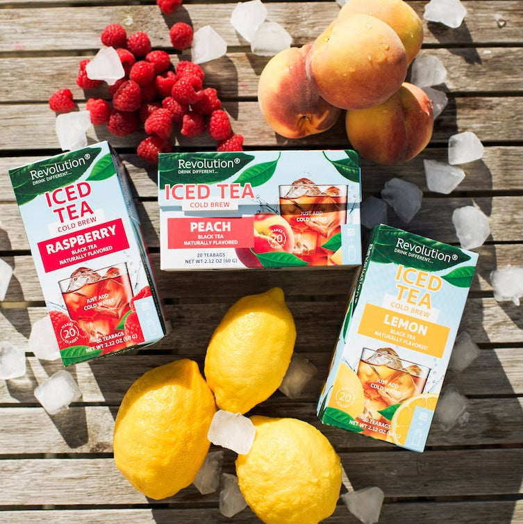 Revolution Iced Tea packages with lemons and fruit on a wooden surface