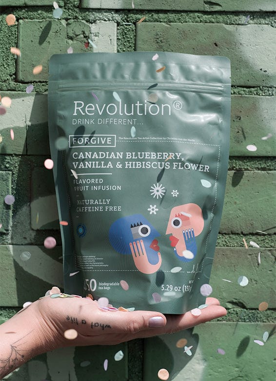 Hand supports Canadian Blueberry, Vanilla & Hibiscus Flower pouch; confetti sprouts.