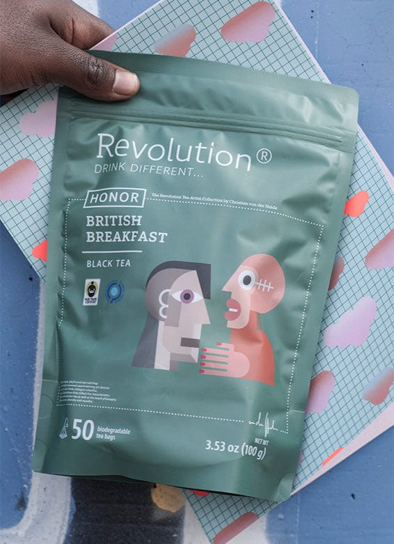 Hand holding a green bag of Revolution British Breakfast black tea.