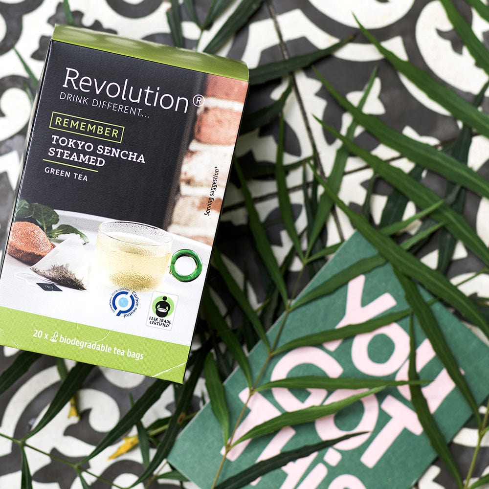 Box of Revolution Tokyo Sencha Steamed green tea on a black and white patterned surface.