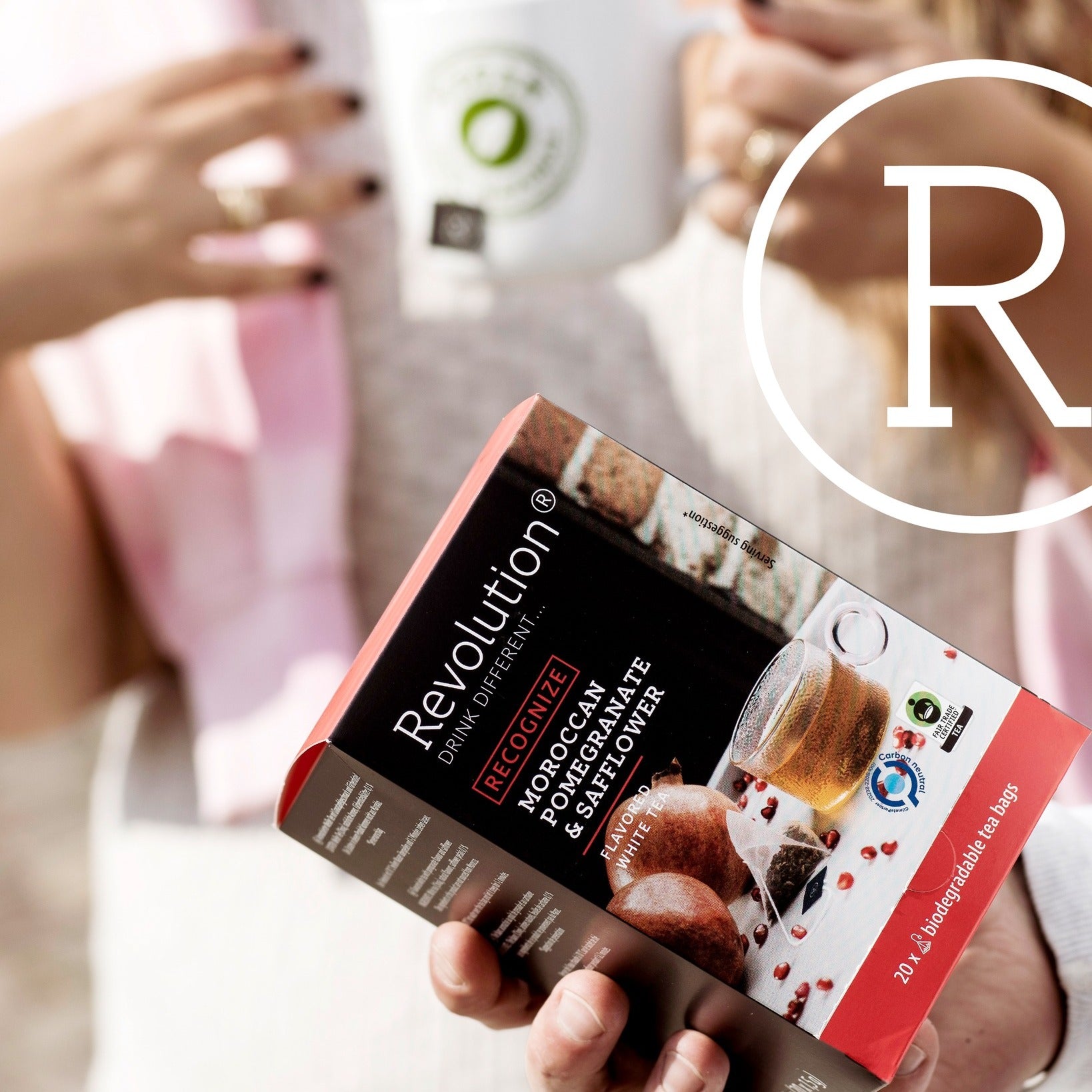 Revolution tea box and a person holding a mug.