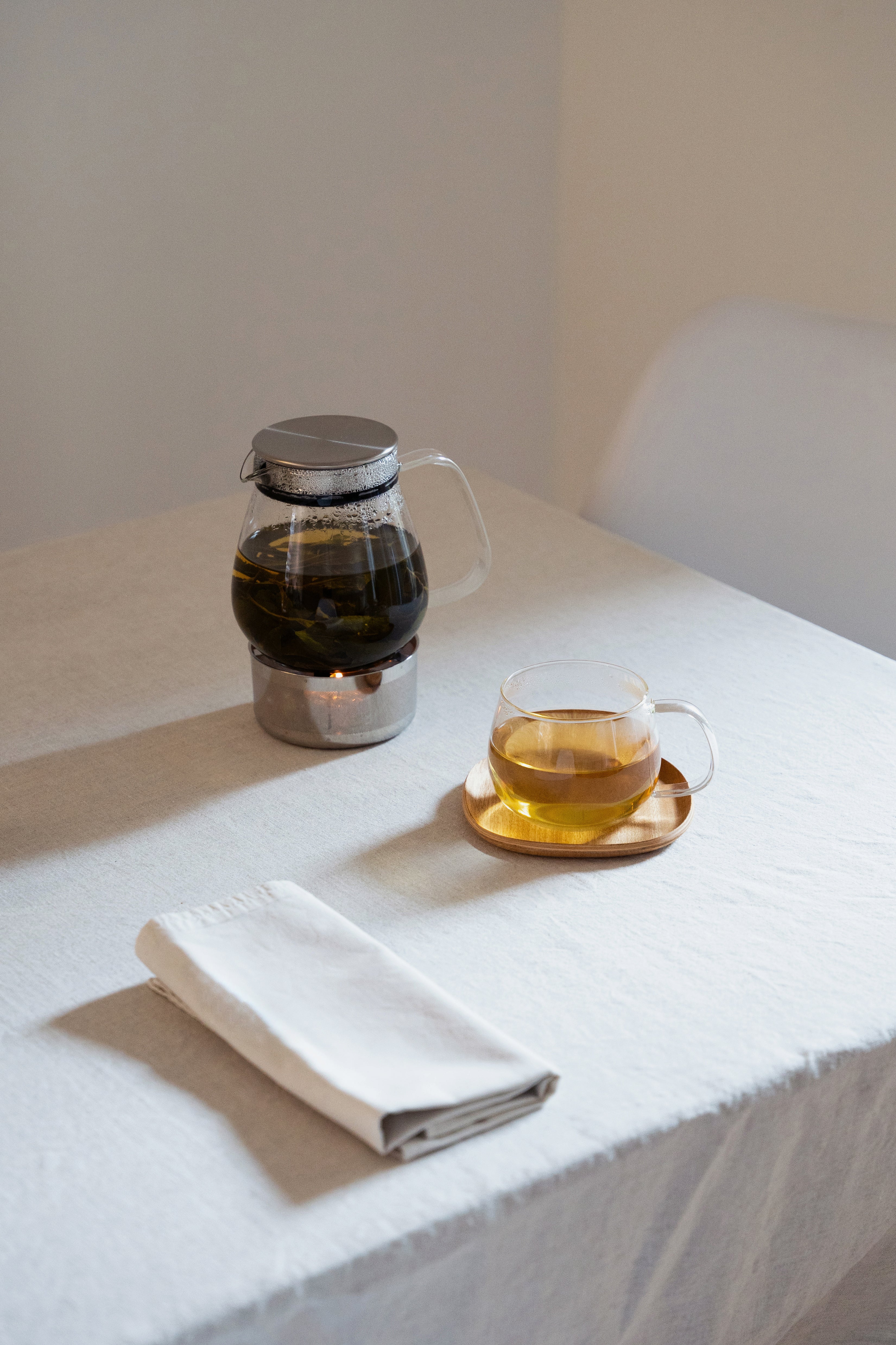 Tea pot and cup on a table with napkin
