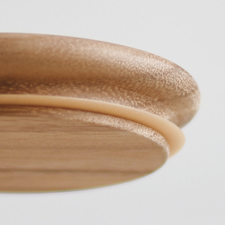 Close-up view of a round wooden lid with a silicone seal.