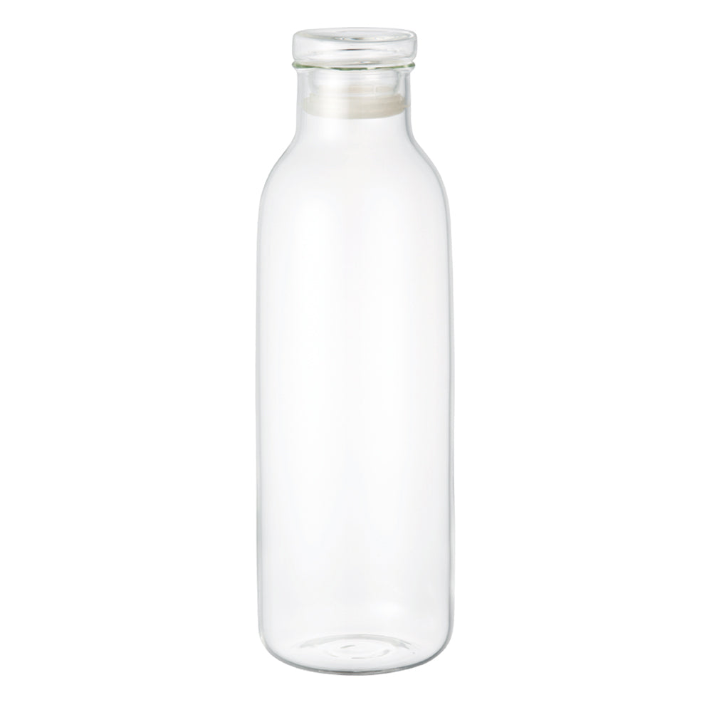 Tall clear glass bottle with a flat base and cylindrical shape, no cap.