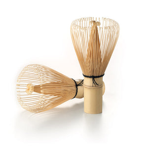Two bamboo matcha whisks on a white background.