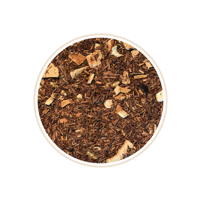 Reddish-brown tea leaves with small light chunks in a circular frame.