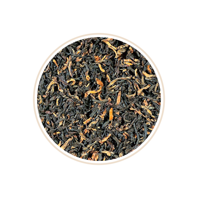 Dark tea leaves with scattered golden tips.